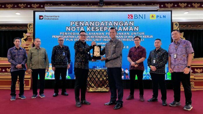 BaliPortalNews_ PLN-BNI General Manager PLN UID Bali Eric Rossi Priyo Nugroho (kanan) menerima cenderamata dari Pemimpin Kantor Wilayah 08 PT Bank Negara Indonesia (Persero) Tbk Komang Arya Wira Kusuma Atmaja usai penandatanganan Nota Kesepahaman di Kantor PLN UID Bali, Denpasar, Selasa (10/3/2026).