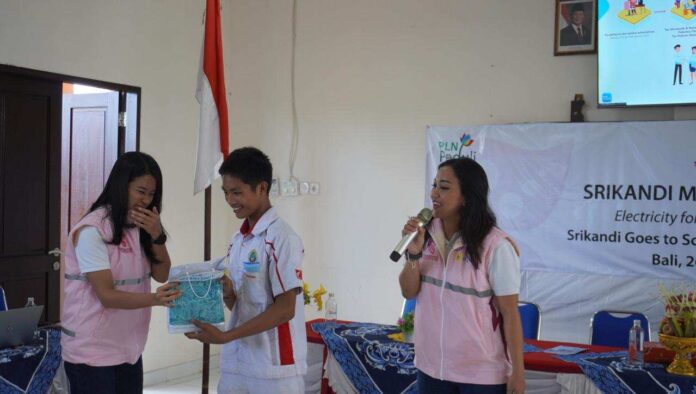 Salah satu siswa SMKN 1 Amlapura yang aktif mengikuti sesi edukasi dan diskusi memperoleh bingkisan dari Srikandi PLN UID Bali dalam kegiatan Srikandi Goes to School, Selasa (26/5). Kegiatan ini menjadi sarana edukasi kendaraan listrik, energi bersih, dan keselamatan ketenagalistrikan bagi generasi muda.