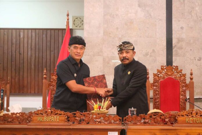 Ketua DPRD Kabupaten Buleleng, Ketut Ngurah Arya menyerahkan draf pandangan dari masing-masing fraksi kepada Wakil Bupati Buleleng Gede Supriatna dalam sidang Paripurna di Gedung Dewan Buleleng. Sumber Foto : Istimewa