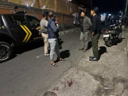 Polisi saat mendatangi TKP dugaan penusukan yang terjadi di Jalan Raya Desa Les, tepatnya di depan Gedung Serbaguna Banjar Dinas Kanginan, Desa Les, Kecamatan Tejakula, Buleleng. Sumber Foto : Istimewa